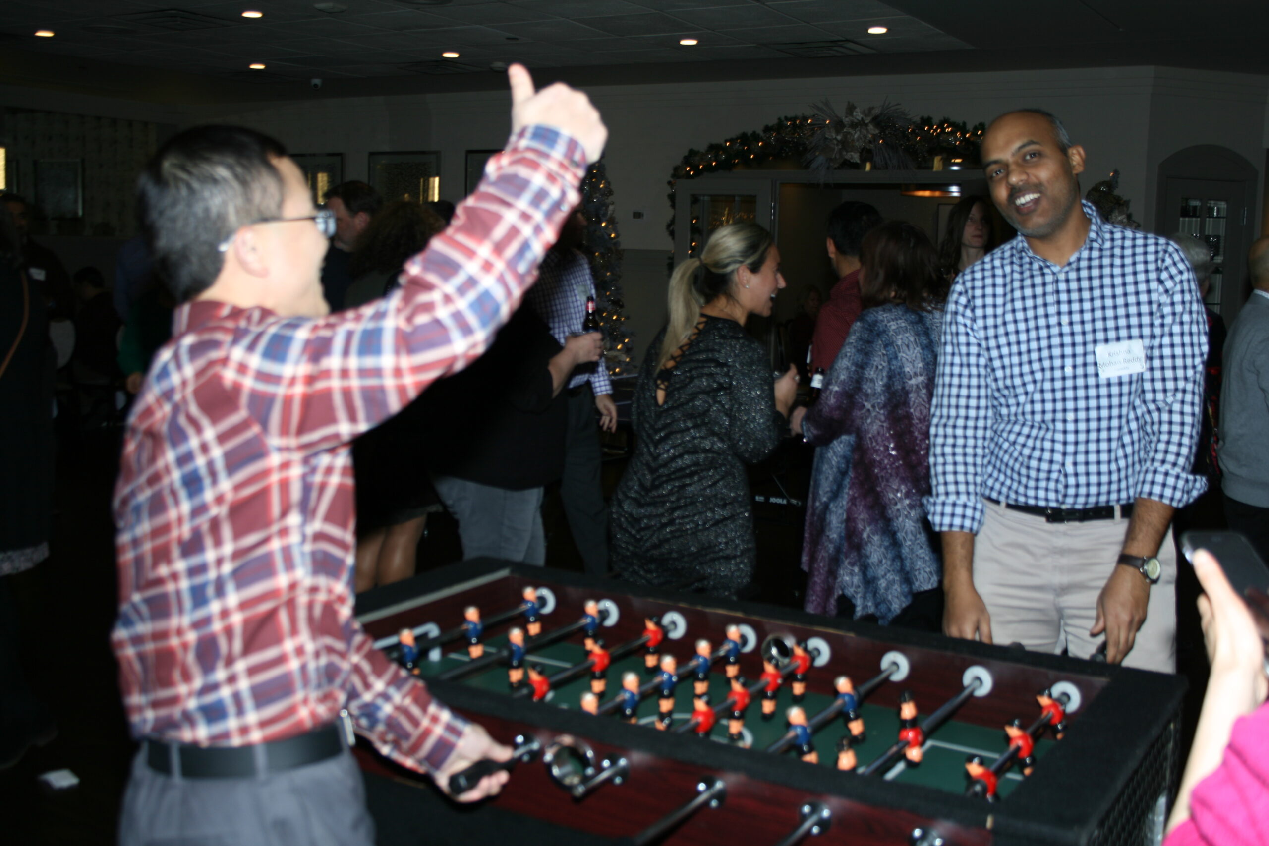 Foosball players enjoying a match at their holiday party